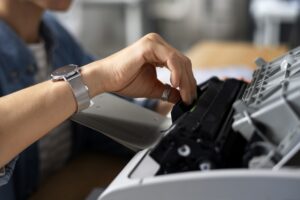 Per un corretto smaltimento di toner e cartucce aziendali, occorre osservare alcune regole. Le sanzioni che si rischiano sono molte, con possibilità di sfociare nel panale. Per evitarle, è sufficiente seguire poche semplici regole. Nella foto, un dipendente d'ufficio che adopera un macchinario da stampa.